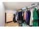 Walk-in closet with a dresser, wooden floor, and shelves with clothes and boxes at 818 Woodward St, Lakeland, FL 33803