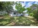 Rear exterior of the home showing white paint and a large yard with plenty of greenery and shade at 818 Woodward St, Lakeland, FL 33803