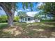 Charming home exterior with large trees, fresh paint, and well-maintained lawn, showing curb appeal at 818 Woodward St, Lakeland, FL 33803