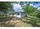 Rear exterior of the home showing sunroom, white paint and a large yard with plenty of greenery and shade at 818 Woodward St, Lakeland, FL 33803