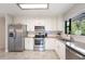 Modern kitchen with white cabinets, stainless steel appliances, and granite countertops, offering modern convenience at 818 Woodward St, Lakeland, FL 33803