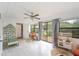Bright sunroom with white tile floor, ceiling fan, playful decor, and large windows at 818 Woodward St, Lakeland, FL 33803