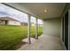 Covered back porch overlooking the backyard with green grass and neighboring houses at 8323 Greystone Dr, Lakeland, FL 33810