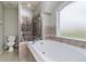 Elegant bathroom with soaking tub, glass-enclosed shower, and tiled accents, creating a spa-like retreat at 8323 Greystone Dr, Lakeland, FL 33810