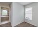 Bright bedroom with carpeted floors and a window, connected to a bathroom with a tub at 8323 Greystone Dr, Lakeland, FL 33810