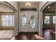 Welcoming foyer with elegant double doors, hardwood floors, and a decorative chandelier at 8323 Greystone Dr, Lakeland, FL 33810