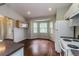 Charming kitchen with bay window, white appliances, and wood floors, perfect for cozy meals at 8323 Greystone Dr, Lakeland, FL 33810