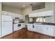 Spacious kitchen with white cabinetry, appliances, and wood floors, offering ample storage at 8323 Greystone Dr, Lakeland, FL 33810