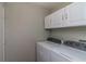 Laundry room with a white washer and dryer, and white cabinets above at 8323 Greystone Dr, Lakeland, FL 33810