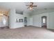 Open-concept living room featuring neutral carpeting and arched doorways that leads to other rooms in the home at 8323 Greystone Dr, Lakeland, FL 33810