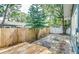 Private fenced backyard featuring a wooden deck, stone patio, and mature trees providing shade and natural beauty at 838 S Tennessee Ave, Lakeland, FL 33801