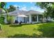 Green backyard featuring the covered patio area, green lawn space and tropical landscaping at 1145 Denton St, Lakeland, FL 33803