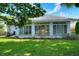 Backyard view of home showcasing the enclosed patio area, green lawn and landscaping at 1145 Denton St, Lakeland, FL 33803