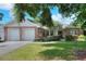 Charming single-story home with a brick facade, a well-manicured lawn, and a two-car garage at 1145 Denton St, Lakeland, FL 33803