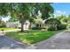 A single-story home with a brick facade, a well-manicured lawn, and mature trees in a residential neighborhood at 1145 Denton St, Lakeland, FL 33803