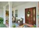 A cozy front porch featuring comfortable seating, a wooden front door, and decorative plants at 1145 Denton St, Lakeland, FL 33803
