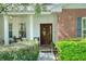 Inviting front porch with brick accents, lush greenery, and a decorative wooden front door at 1145 Denton St, Lakeland, FL 33803