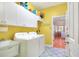 Bright yellow laundry room with sink, cabinets, and washer dryer at 1145 Denton St, Lakeland, FL 33803