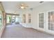 Enclosed sunroom with ceiling fans and backyard view through glass windows at 1145 Denton St, Lakeland, FL 33803