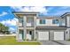 Modern townhome featuring light gray paint, a two-car garage, and a charming, light blue front door at 1170 Windjammer Dr, Lakeland, FL 33803