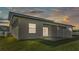 Back exterior of home featuring well manicured lawn and private patio at sunset at 1170 Windjammer Dr, Lakeland, FL 33803