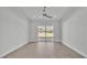 Open living room with wood-look tile flooring and sliding glass doors at 1170 Windjammer Dr, Lakeland, FL 33803