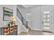 Bright foyer with front door, modern staircase and railing, window with zebra shade, and accent table at 1170 Windjammer Dr, Lakeland, FL 33803