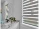 Elegant bathroom featuring a marble countertop, modern faucet, and bright, stylish window blind at 1172 Windjammer Dr, Lakeland, FL 33803