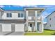Contemporary two-story house boasting a balcony, paver driveway, and vibrant green lawn at 1172 Windjammer Dr, Lakeland, FL 33803