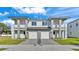 Modern two-story duplex featuring a paver driveway, private balconies, and manicured lawn at 1172 Windjammer Dr, Lakeland, FL 33803