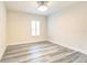 Empty bedroom featuring wood-look flooring, a ceiling fan, and a window with white shutters at 11761 Bella Milano Ct, Windermere, FL 34786