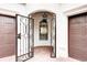 Exterior entryway featuring a black iron gate, brick flooring, and access to garage at 11761 Bella Milano Ct, Windermere, FL 34786