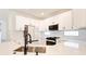 Kitchen with white cabinets, stainless steel appliances, and a sink featuring modern fixtures and white countertops at 11761 Bella Milano Ct, Windermere, FL 34786