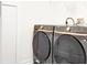 A modern laundry room features a black Samsung washer and dryer with rose gold accents at 11761 Bella Milano Ct, Windermere, FL 34786