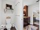 Bathroom with white toilet, wood floors, floating shelf and views of the bedroom vanity at 1307 Fairlee St, Lakeland, FL 33813