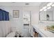 Charming bathroom with a classic sink, wainscoting, and access to an adjacent bedroom at 1307 Fairlee St, Lakeland, FL 33813