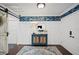 Charming foyer features blue floral wallpaper, vintage chest, round mirror, and decorative rug at 1307 Fairlee St, Lakeland, FL 33813