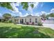 Single-story home with a manicured lawn, arch windows, and concrete driveway at 1307 Fairlee St, Lakeland, FL 33813