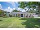 Charming single-story home featuring an arch window design, manicured lawn and landscaping at 1307 Fairlee St, Lakeland, FL 33813