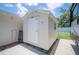 A storage shed with a white door is adjacent to a parking space at 1307 Fairlee St, Lakeland, FL 33813