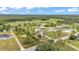 A wide aerial perspective revealing a community nestled amidst green pastures and forested areas at 13522 Rockridge Rd, Lakeland, FL 33809