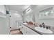 Stylish bathroom showcasing a double sink vanity, granite countertop, and white tiled shower with glass door at 13522 Rockridge Rd, Lakeland, FL 33809