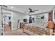 Bright bedroom with neutral carpet, large window, ceiling fan, and view into ensuite bathroom at 13522 Rockridge Rd, Lakeland, FL 33809