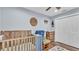 Charming Bedroom showcasing a wooden crib, glider chair, closet, and wood look floors at 13522 Rockridge Rd, Lakeland, FL 33809