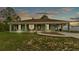 Charming single-story home featuring a welcoming front porch and covered carport at sunset at 13522 Rockridge Rd, Lakeland, FL 33809