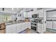 Kitchen boasts white cabinets, stainless appliances, granite counters and adjacent laundry room at 13522 Rockridge Rd, Lakeland, FL 33809