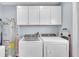 Functional laundry room with washer, dryer, storage cabinets, and water heater at 13522 Rockridge Rd, Lakeland, FL 33809
