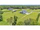 Expansive aerial showcasing a large farmhouse with a barn, complemented by lush greenery at 1385 Ewell Rd, Lakeland, FL 33811