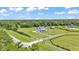 Expansive aerial view of a property showcasing its large lot, gated entrance, and proximity to lush greenery at 1385 Ewell Rd, Lakeland, FL 33811