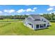 Aerial view of the back of a two-story home with a large yard and fenced pastures at 1385 Ewell Rd, Lakeland, FL 33811